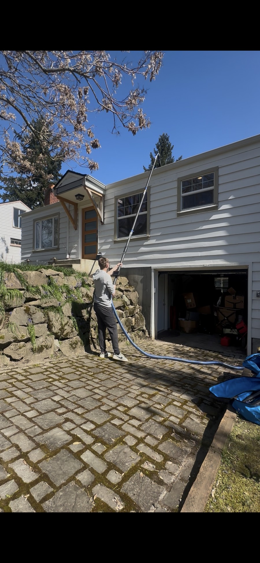 Ian Smith cleaning gutters from the ground with a SkyVac vacuum system